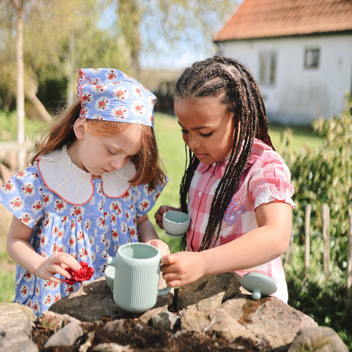 Child playing a pretend tea party with the Mushie silicone tea set