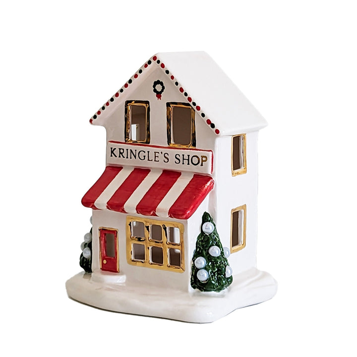 Decorative ceramic house with 'Kringle's Shop' sign on a white background