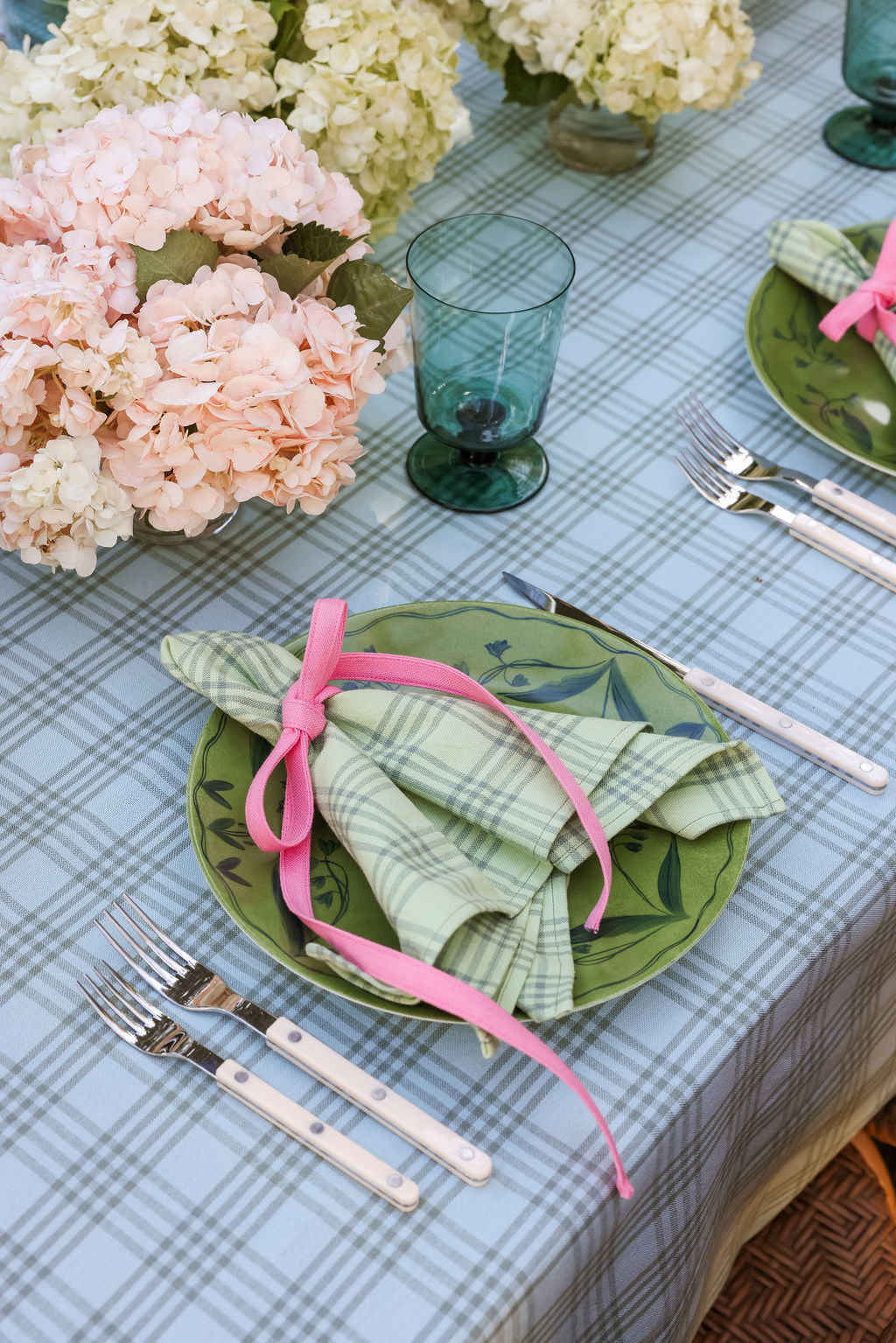 Sprout green napkins on a spring table with hydrangea, green glassware, and blue gingham