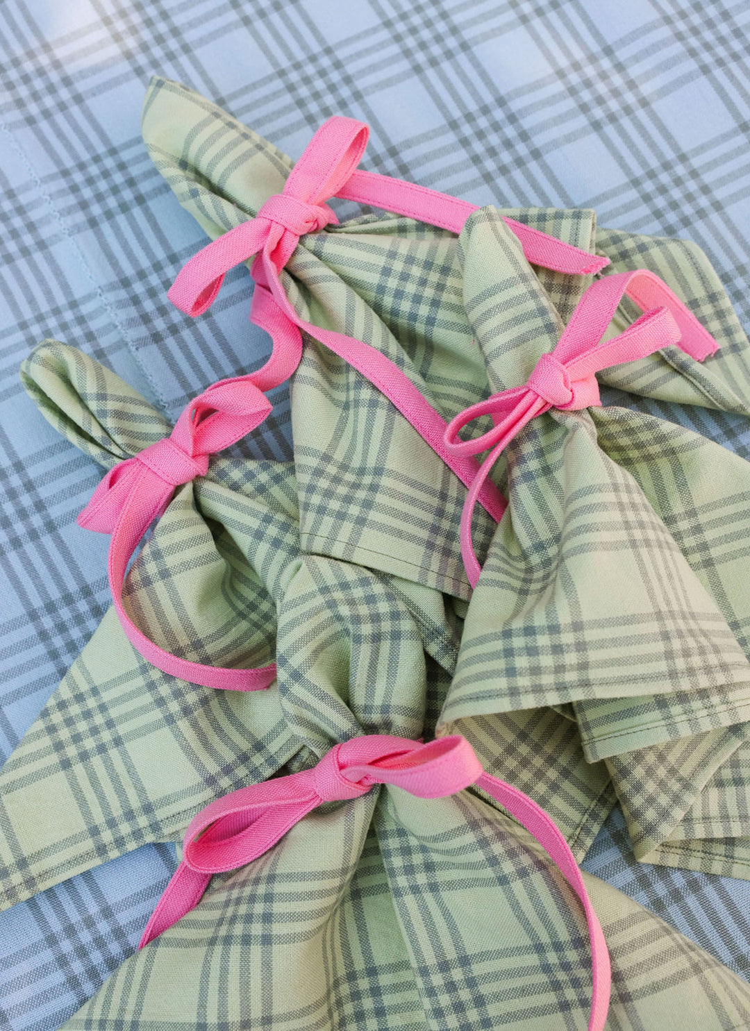 Montauk sprout green cloth napkins tied with pink ribbon on a blue gingham cloth