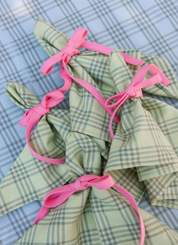 Montauk sprout green cloth napkins tied with pink ribbon on a blue gingham cloth