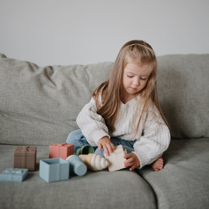 Child playing with the Mushie mix and match ice cream toy