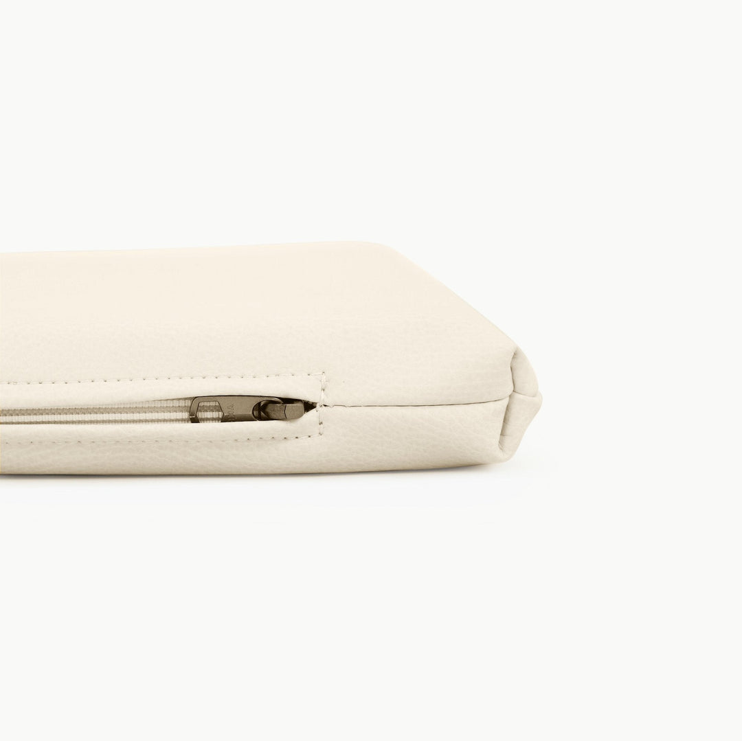 Close-up of the zippered edge on the ivory vegan leather padded play mat