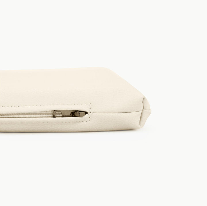 Close-up of the zippered edge on the ivory vegan leather padded play mat
