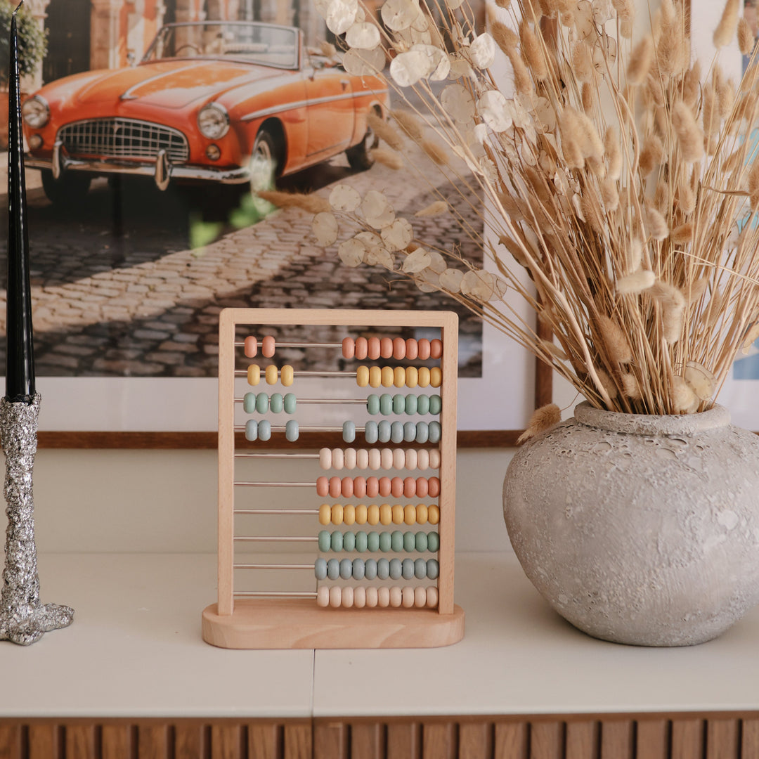 Child with the Mushie wooden abacus