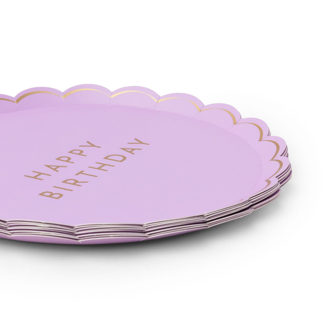 Stack of lilac Happy Birthday party plates with scalloped gold-trimmed edge