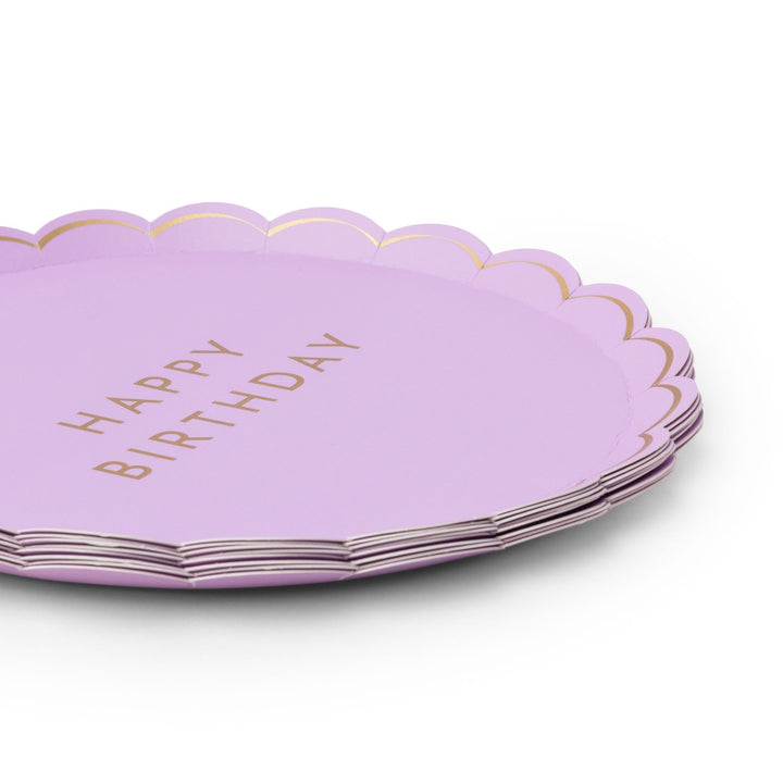Stack of lilac Happy Birthday party plates with scalloped gold-trimmed edge