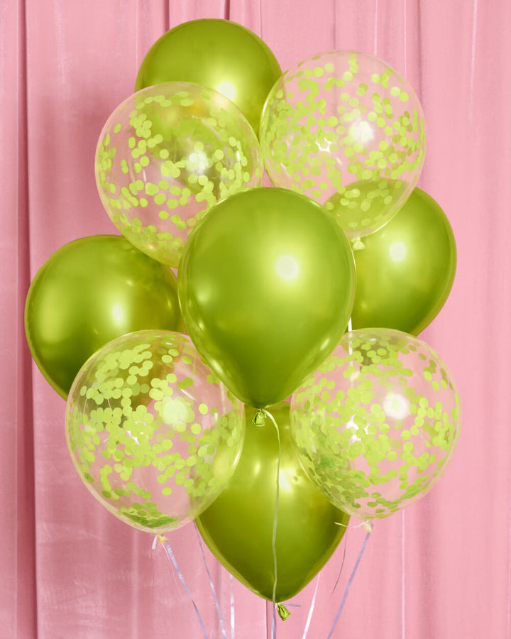 Bunch of lime green metallic and clear confetti latex balloons on a pink backdrop