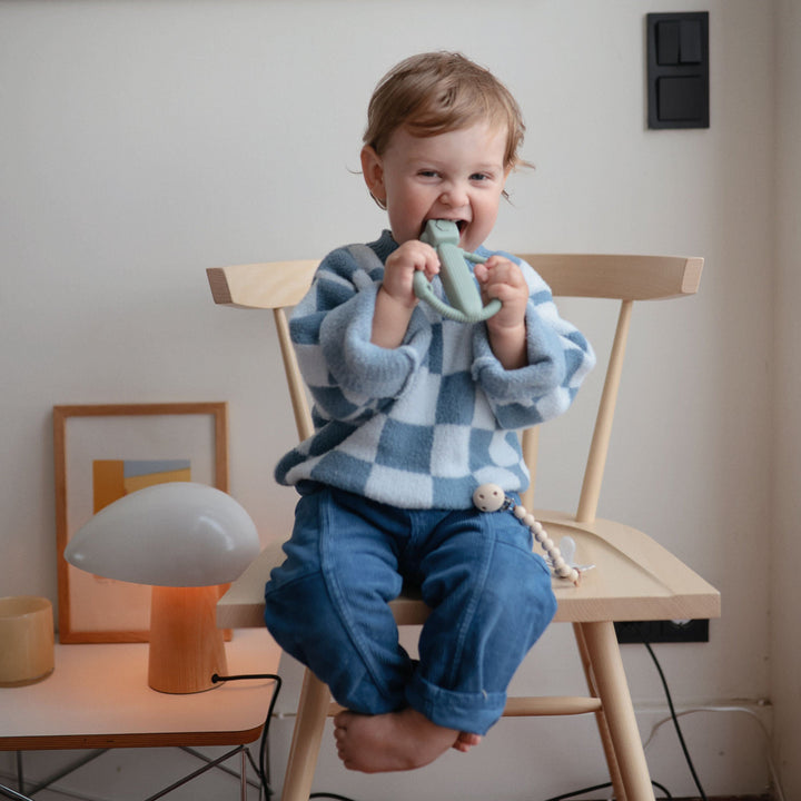 Baby with a Mushie silicone rattle teether