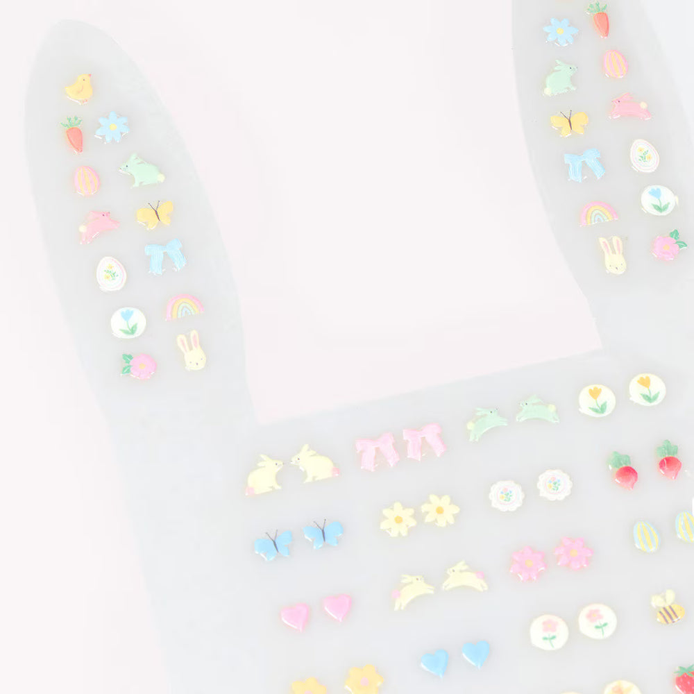 Close-up of pastel Easter stick-on earrings with paired bunny, chick, carrot, butterfly, flower and rainbow designs.