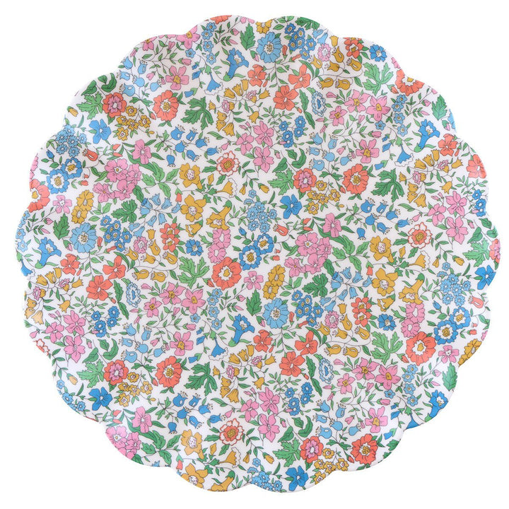 White scalloped melamine plate densely printed with blue, pink and orange Liberty flowers and green foliage.