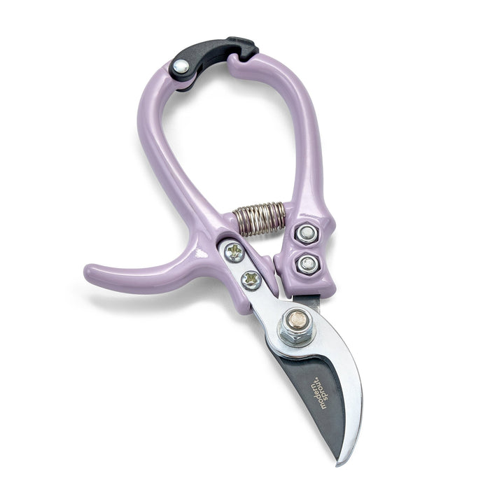Lavender bypass pruners with closed curved blades and a coil spring on white