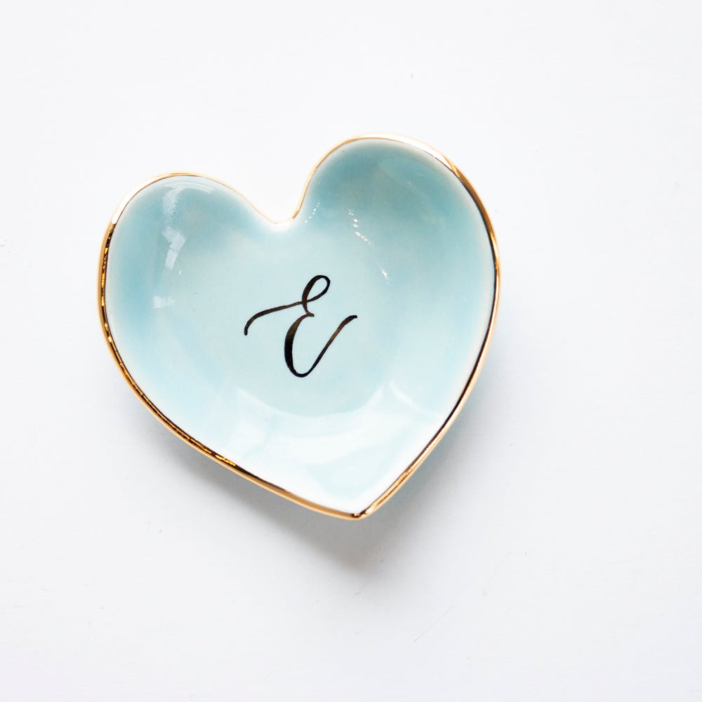 Light aqua heart dish with a black script initial E and a gold rim