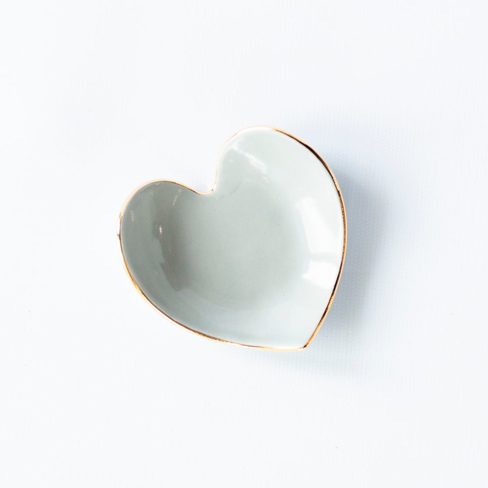 Pale stone gray heart ring dish with a gold rim on white