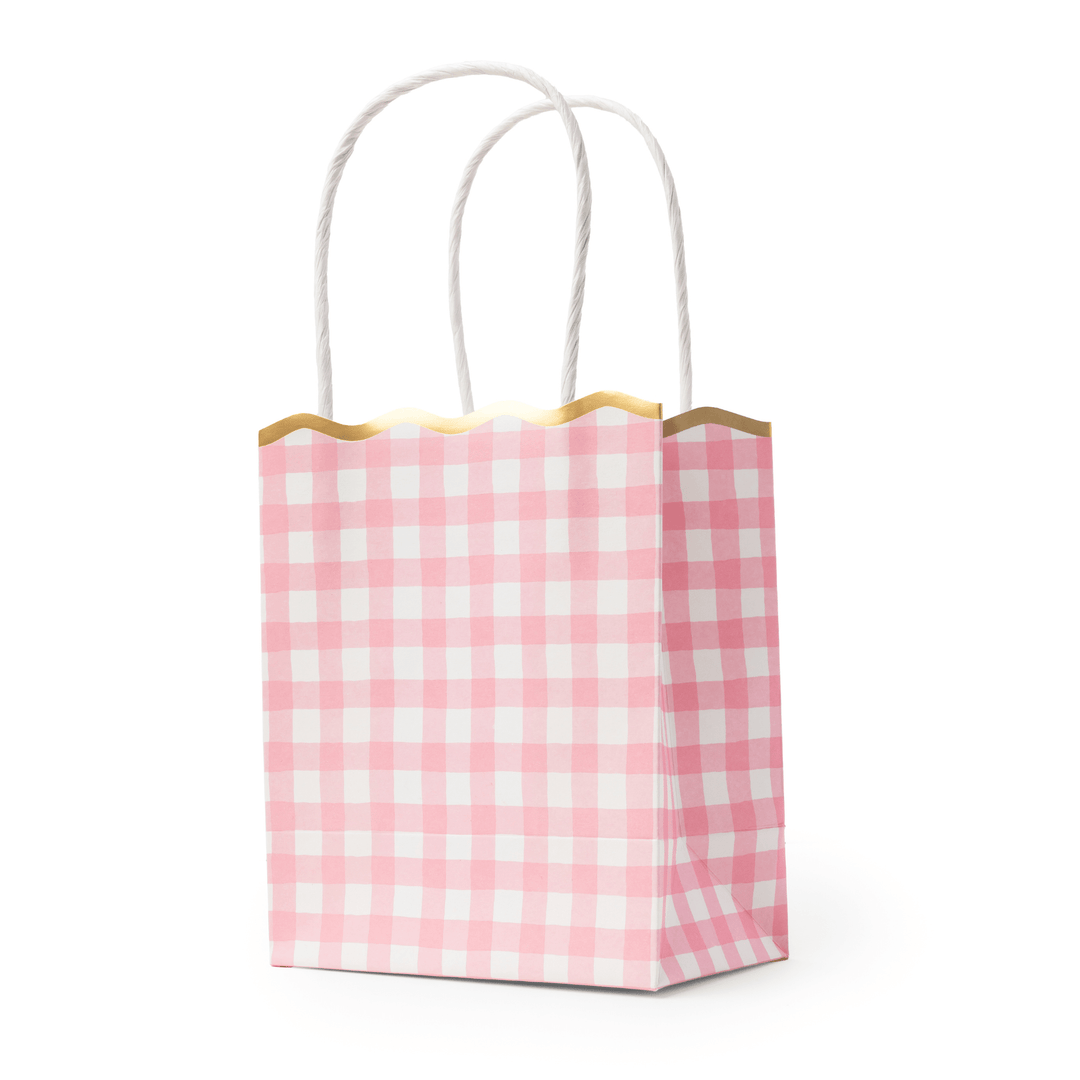 Stack of petal pink gingham favor bags showing the checked pattern and scalloped edge