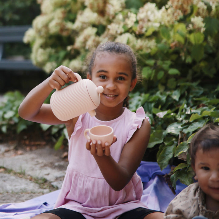 Child enjoying a pretend tea party with the Mushie silicone tea set
