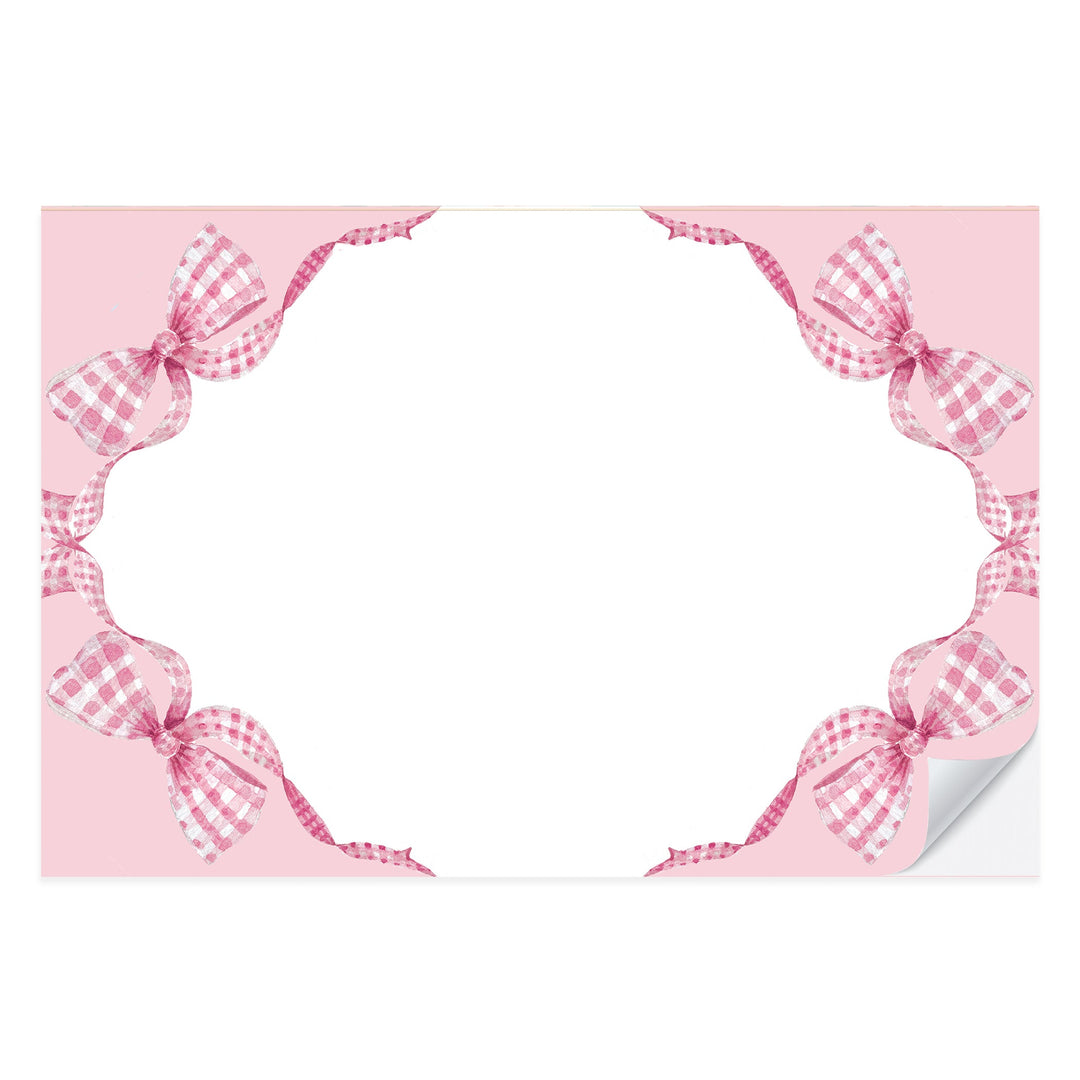 Pink gingham paper placemat with a painted bow at the center, from a tear-off pad of 25