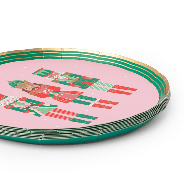 Stack of pink nutcracker Christmas plates showing the scalloped rim design