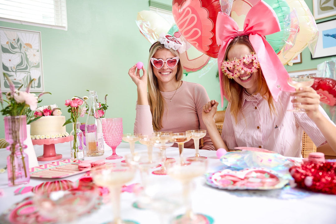 Twelve champagne coupes and pink pong balls for a game of champagne pong