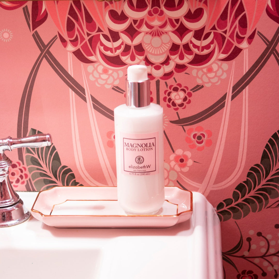 Pink petite valet tray on a vanity holding a lotion bottle against pink floral wallpaper, a spa day gift