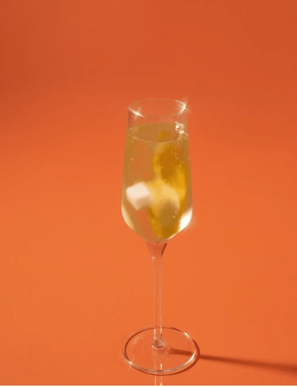 Champagne flute of mimosa made with citrus mixer cubes, styled on a brunch table with flowers