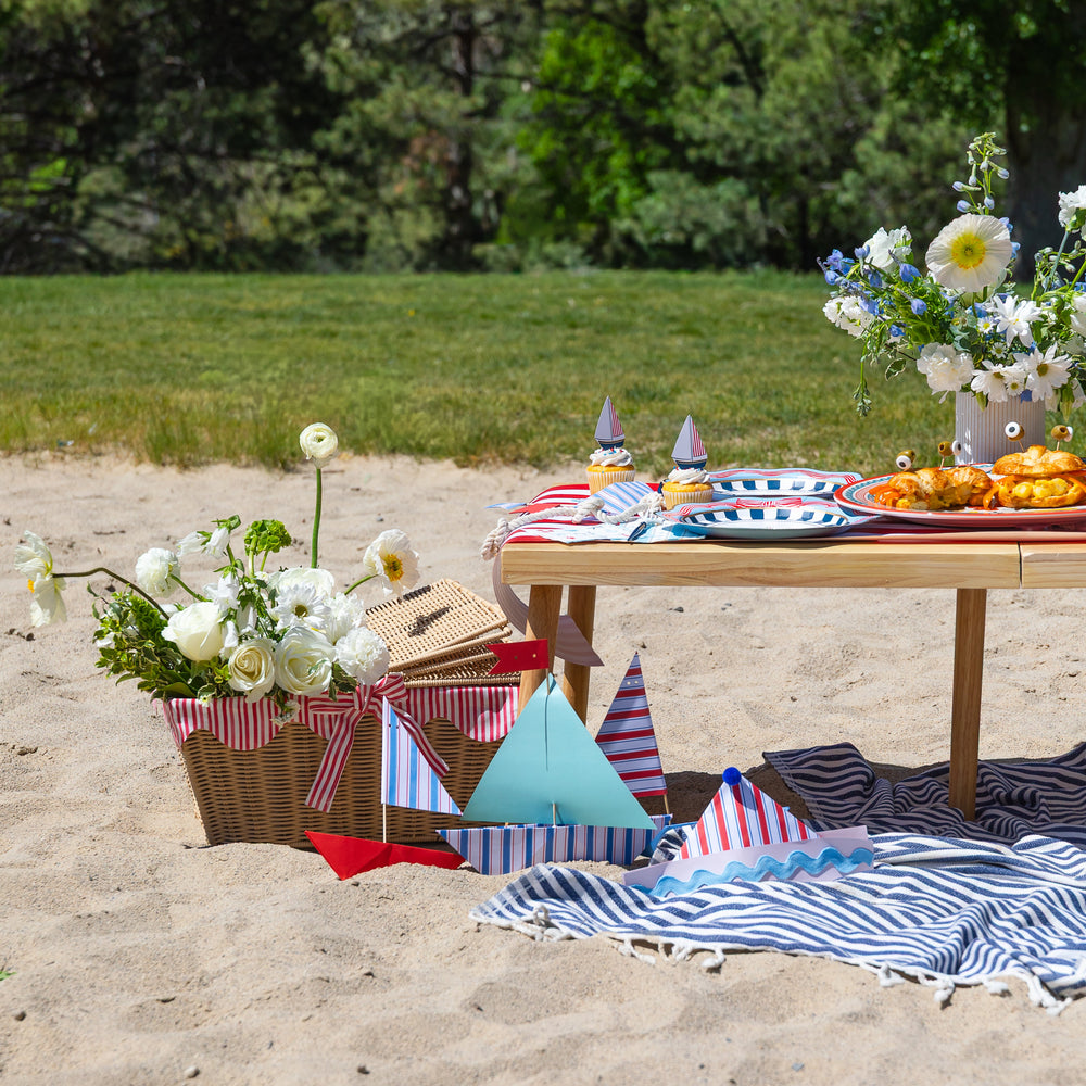 Sailor party hats worn at a Bonjour Fete summer sailing party with nautical and patriotic picnic decor