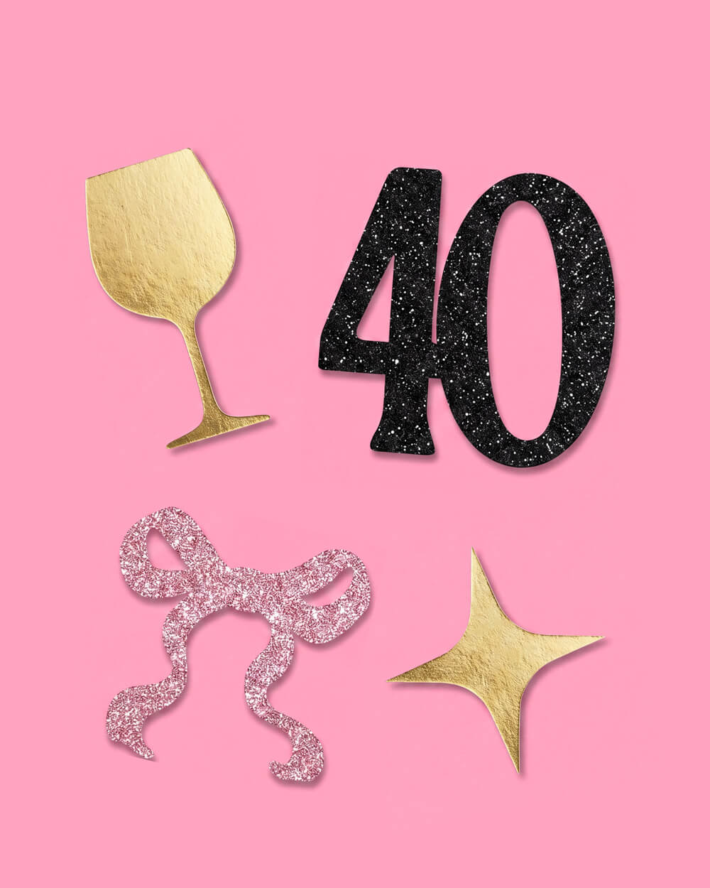 Close view of a black glitter 40, gold wine glass, pink glitter bow, and gold star