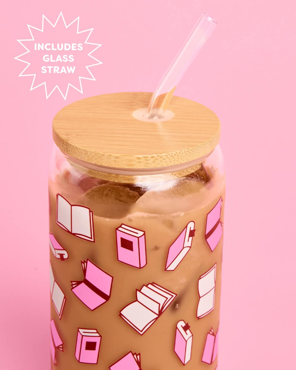 Close-up of the pink book print, bamboo lid, and curved glass straw on the 16 oz glass tumbler