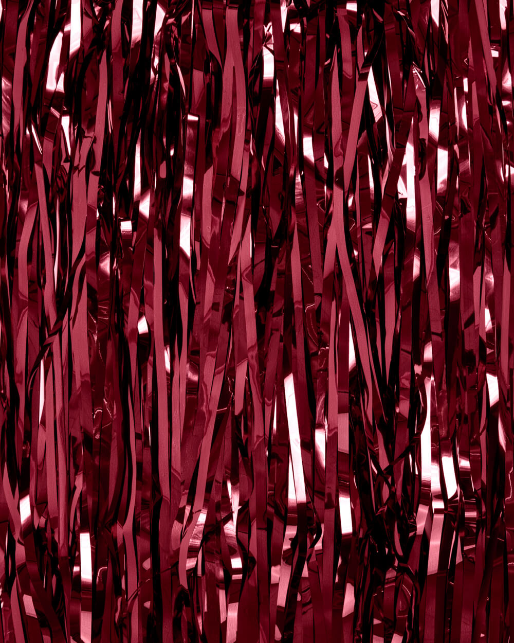Close-up of burgundy foil fringe strands catching light at an angle
