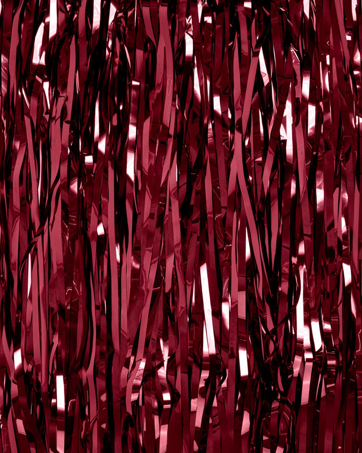 Close-up of burgundy foil fringe strands catching light at an angle