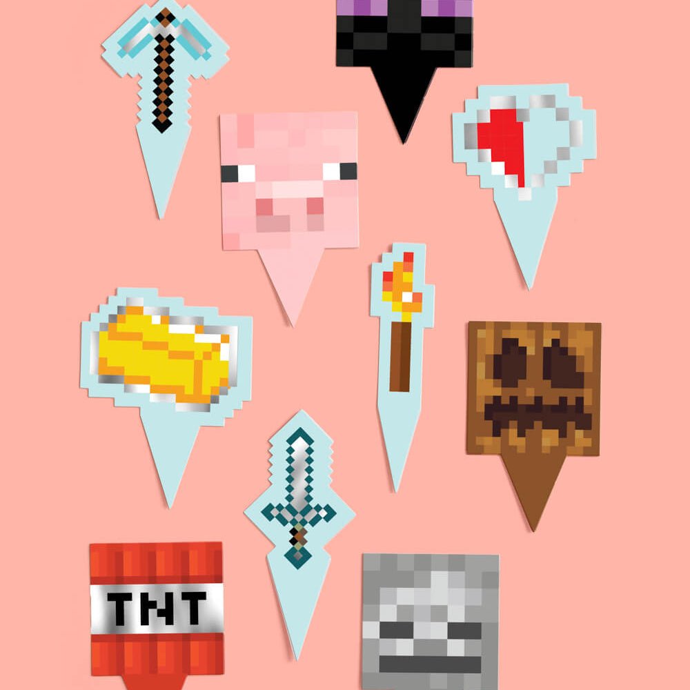 Pixel mining cupcake set by xo Fetti with grass-block wrappers and pixel toppers including a pig, torch, and gold bar