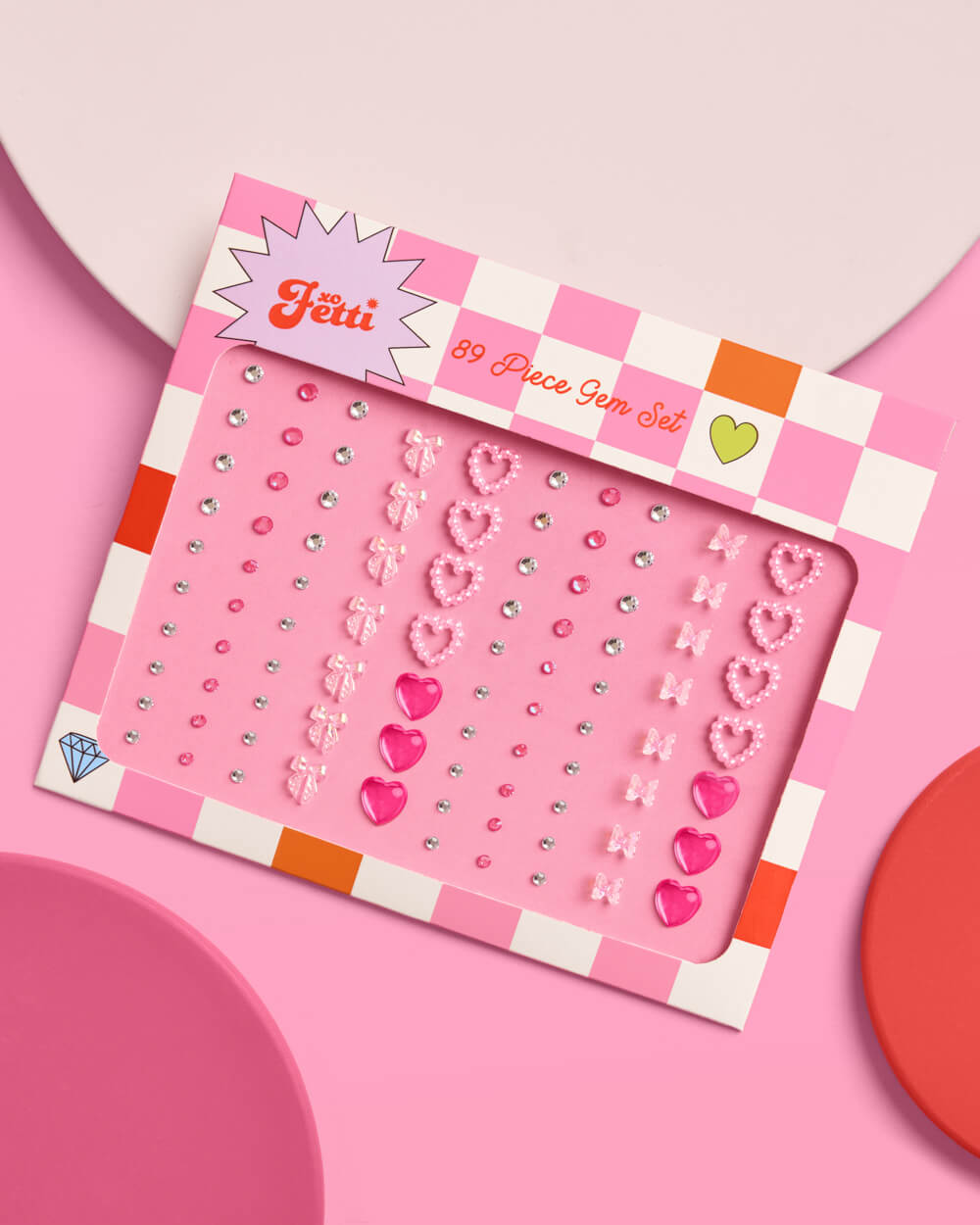 Pink embellishment gem set with decorative elements on a pink background