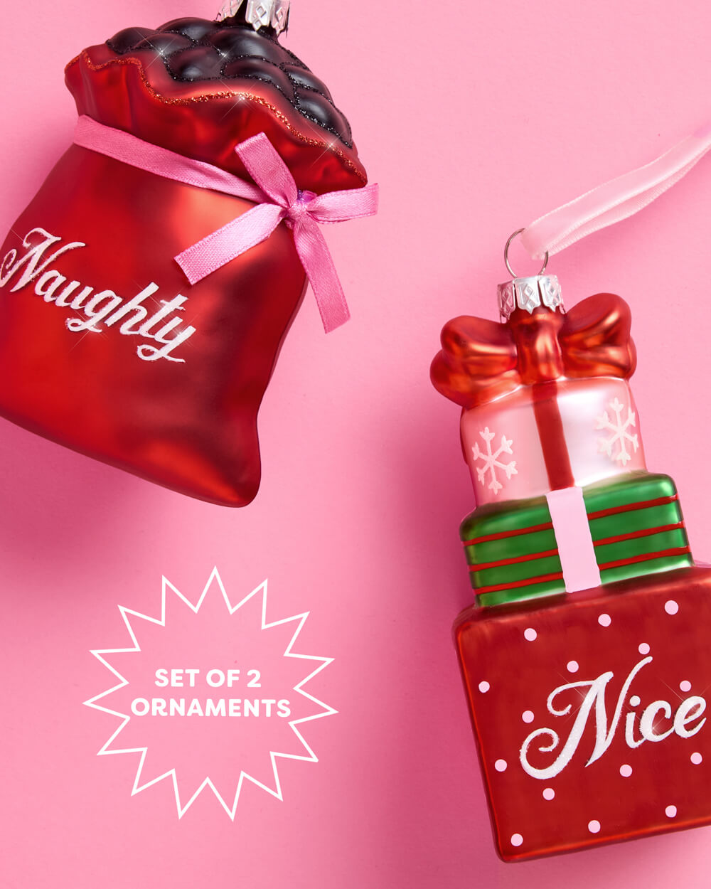 Another view of the Naughty and Nice ornament set, a red coal sack and stacked gift boxes in glass with pink velvet ribbons.