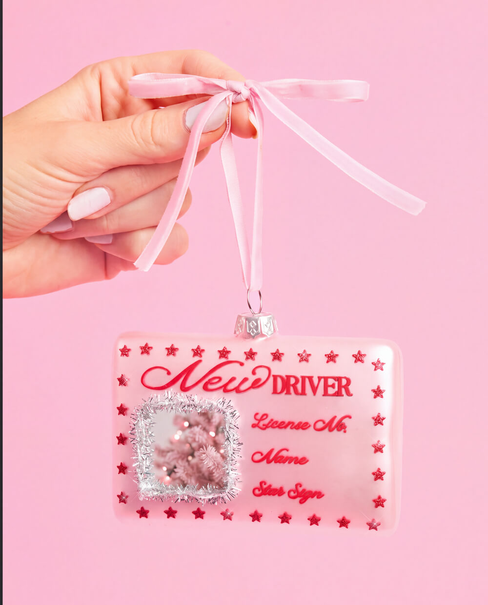 Another view of the pink New Driver license ornament, with its red script lettering and printed red stars.