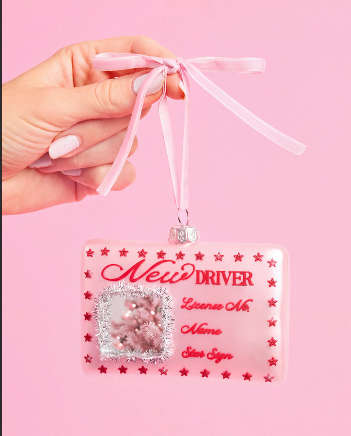 Another view of the pink New Driver license ornament, with its red script lettering and printed red stars.