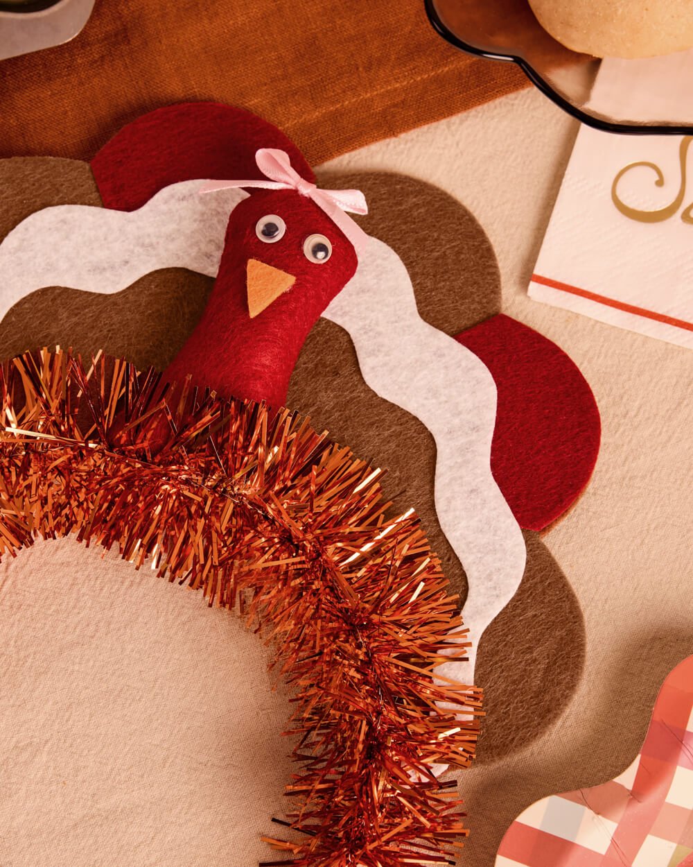 Turkey Thanksgiving headband styled on a fall table beside plaid linens
