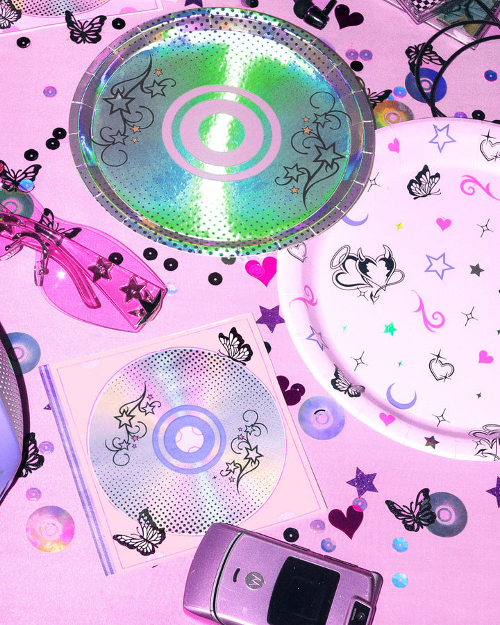 Y2K CD napkins and dessert plate styled with a flip phone, sunglasses, and pink confetti