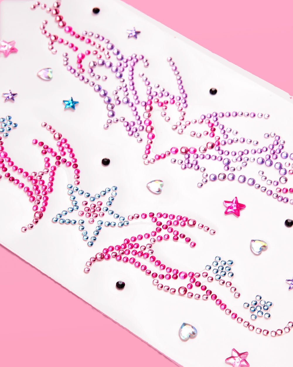 Close-up of pink and purple rhinestone swirls and stars on a Y2K self-adhesive body gem sheet