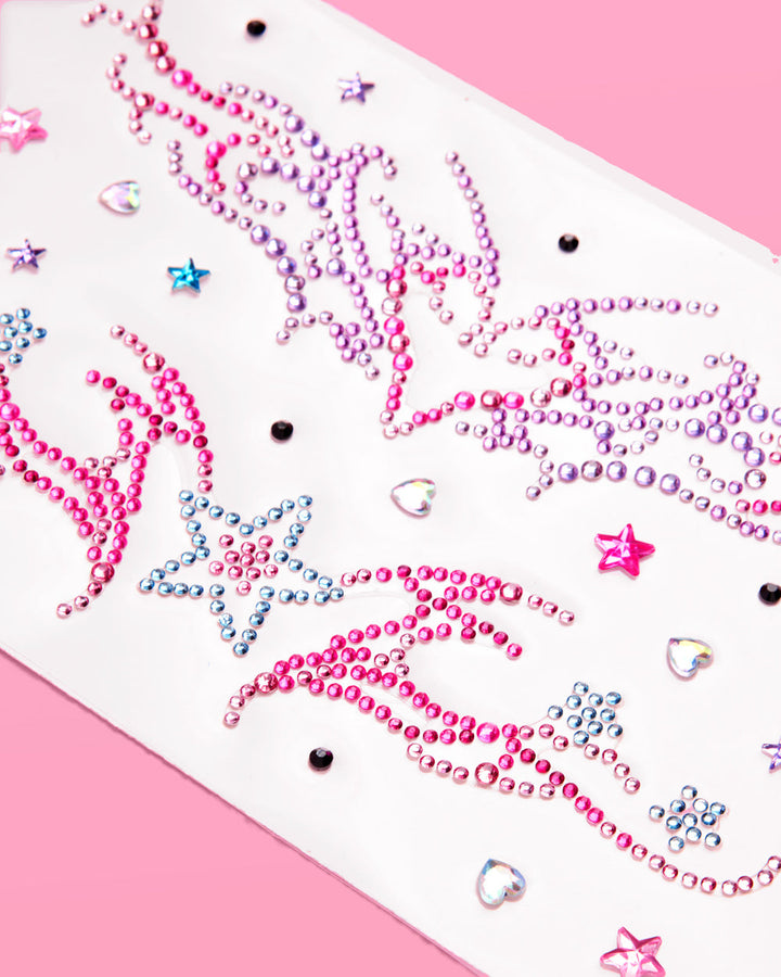 Close-up of pink and purple rhinestone swirls and stars on a Y2K self-adhesive body gem sheet
