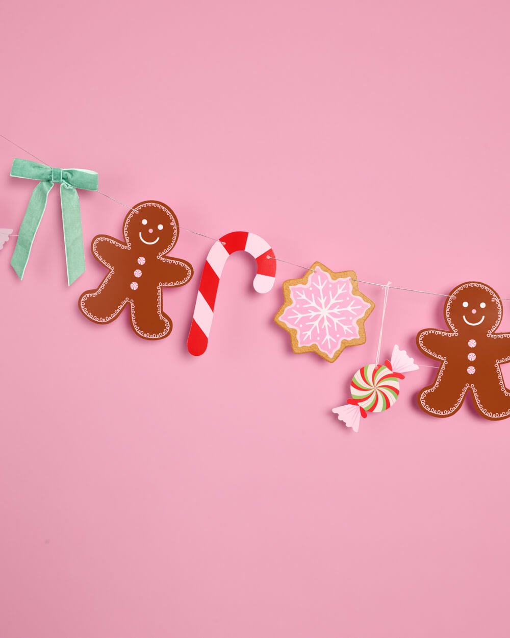 Light green velvet bow tied beside a gingerbread man on the garland