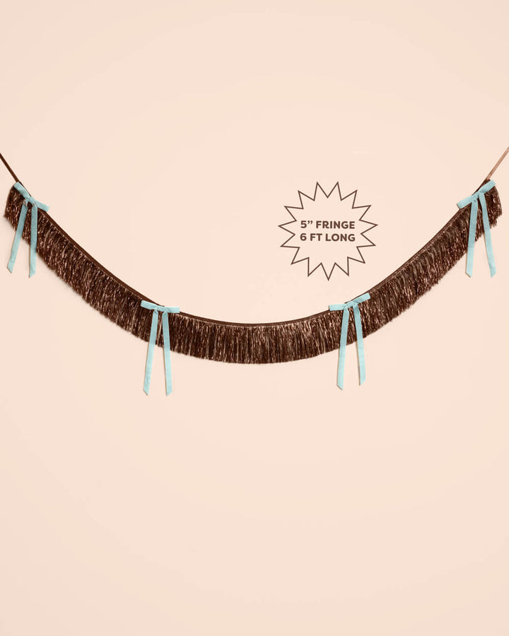 Brown fringe bow banner shown flat with a starburst label reading 5 inch fringe, 6 feet long, for party backdrops