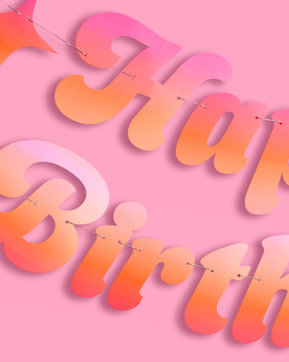 Detail of the glossy ombre cursive letters and string on the Happy Birthday banner