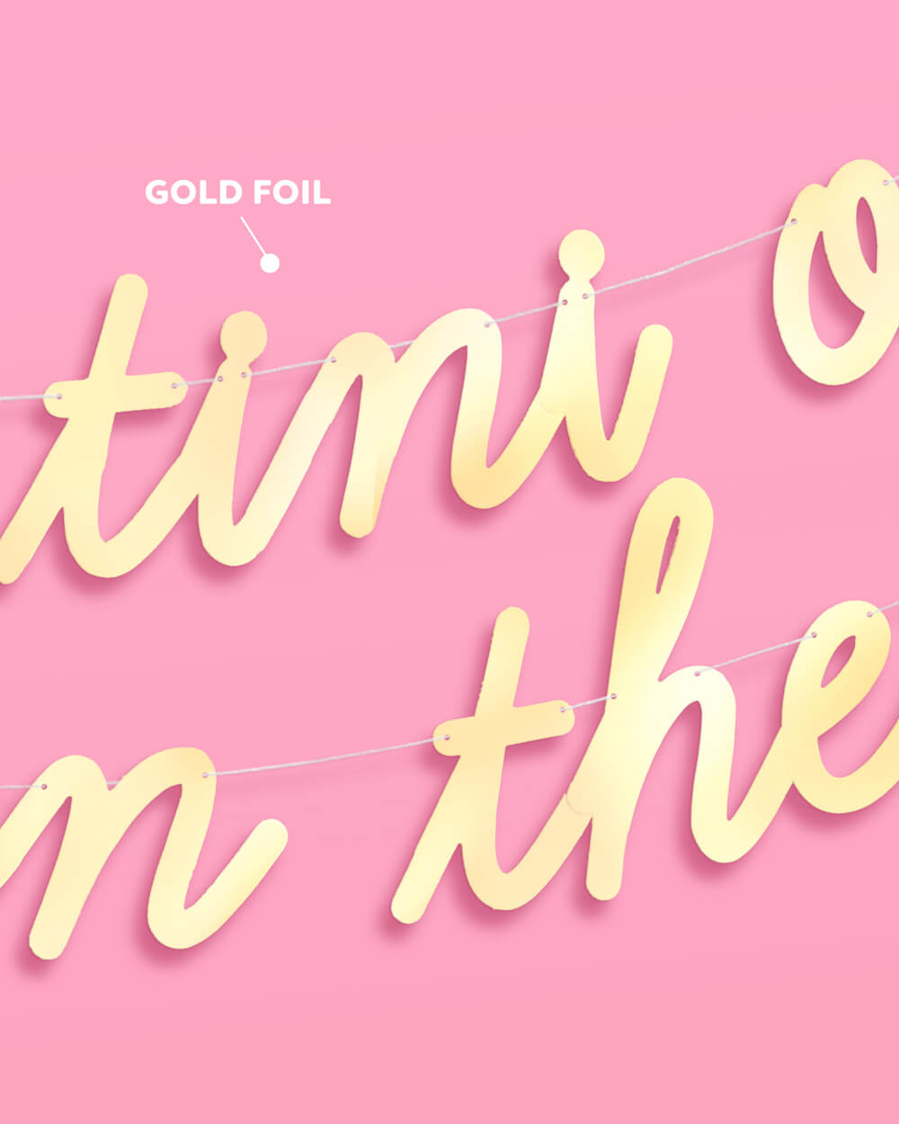 Close-up of shiny gold foil script letters on the baby shower banner, with a gold foil callout