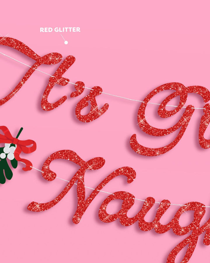 Red glitter cursive lettering and green holly detail on the It's Giving Naughty banner