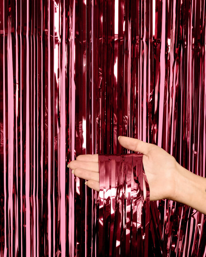 Burgundy metallic fringe curtain against a pink wall showing the wine red shine