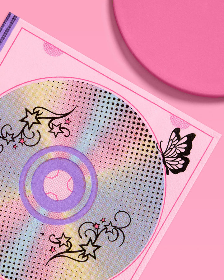 Close-up of an iridescent CD and black butterfly print on a Y2K paper cocktail napkin