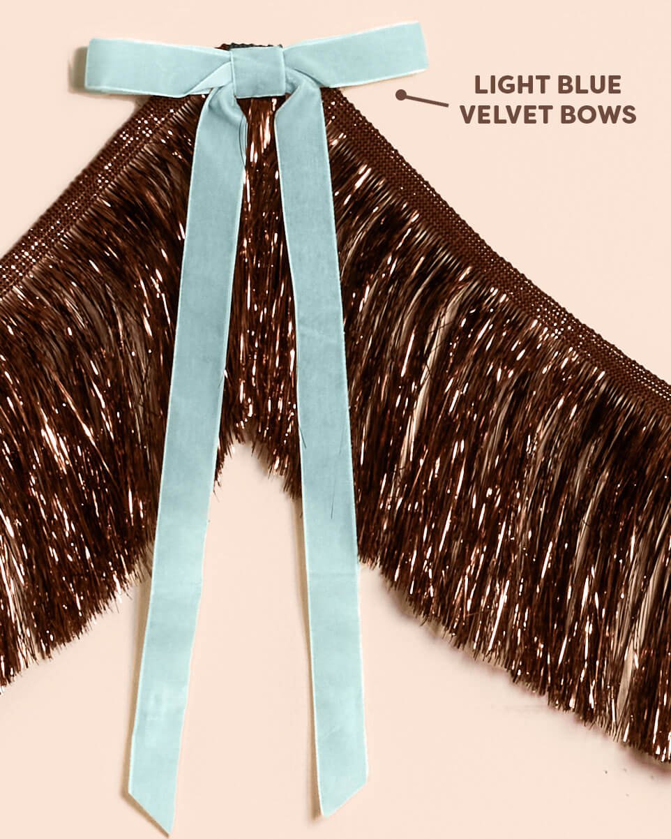 Close-up of the light blue velvet bows tied along the 6 foot brown metallic fringe banner, labeled light blue velvet bows