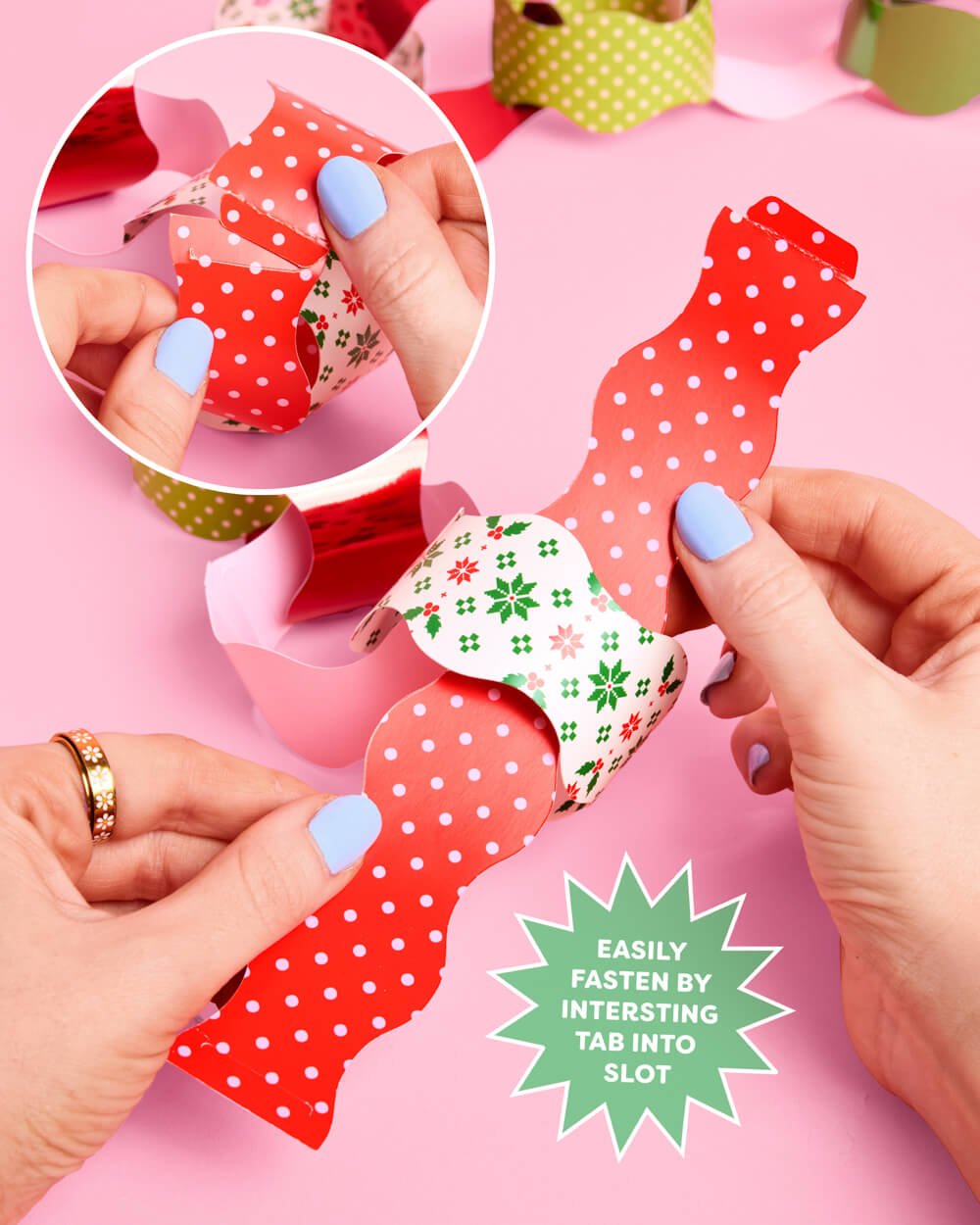 Hands fastening a red polka dot paper strip by inserting the tab into the slot