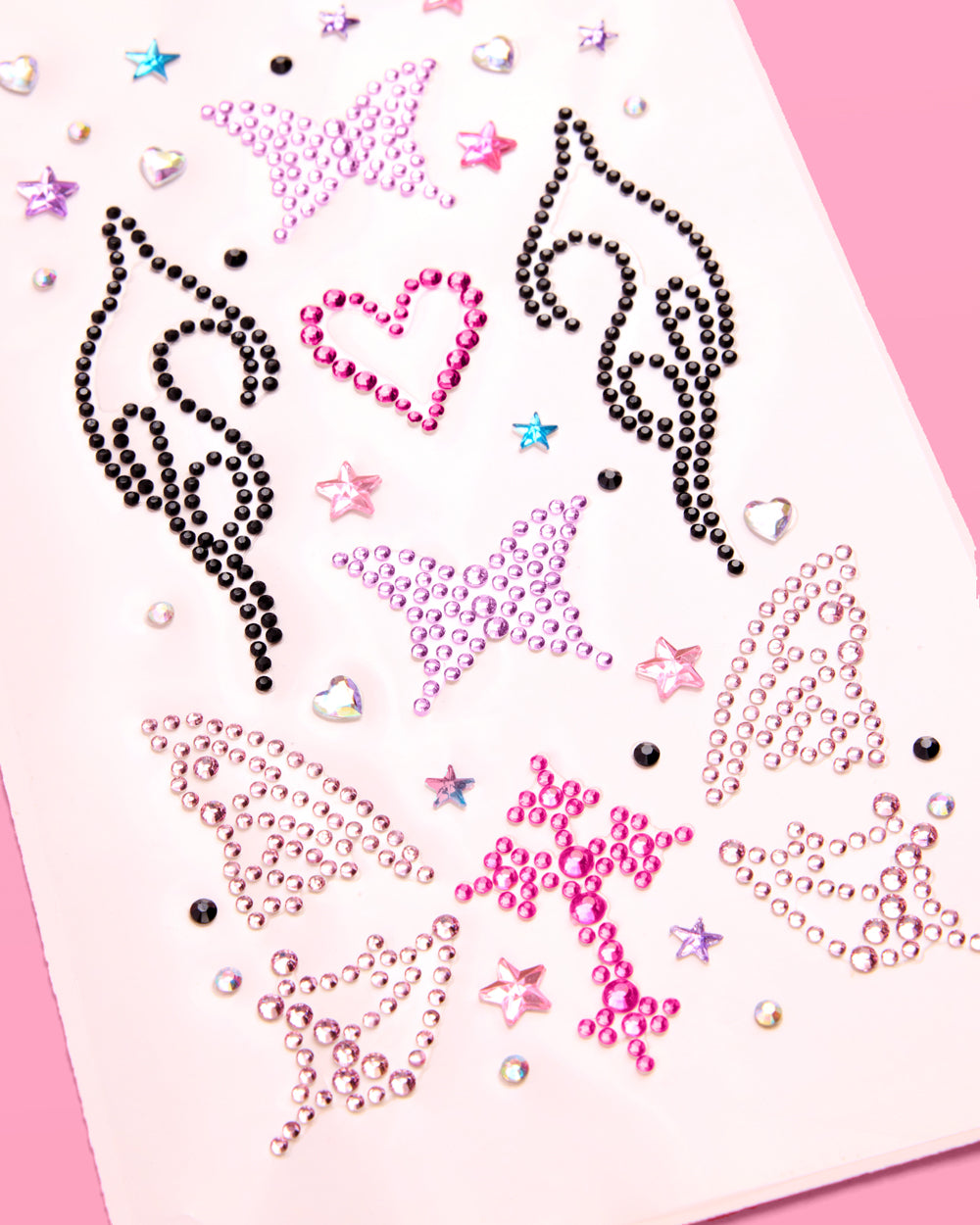Close-up of black flame, pink heart, and lavender butterfly rhinestones on the Y2K face gem sheet