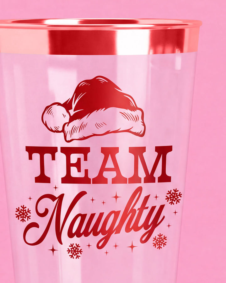 Close-up of the Team Naughty cup print with a red foil Santa hat, snowflakes, and script lettering